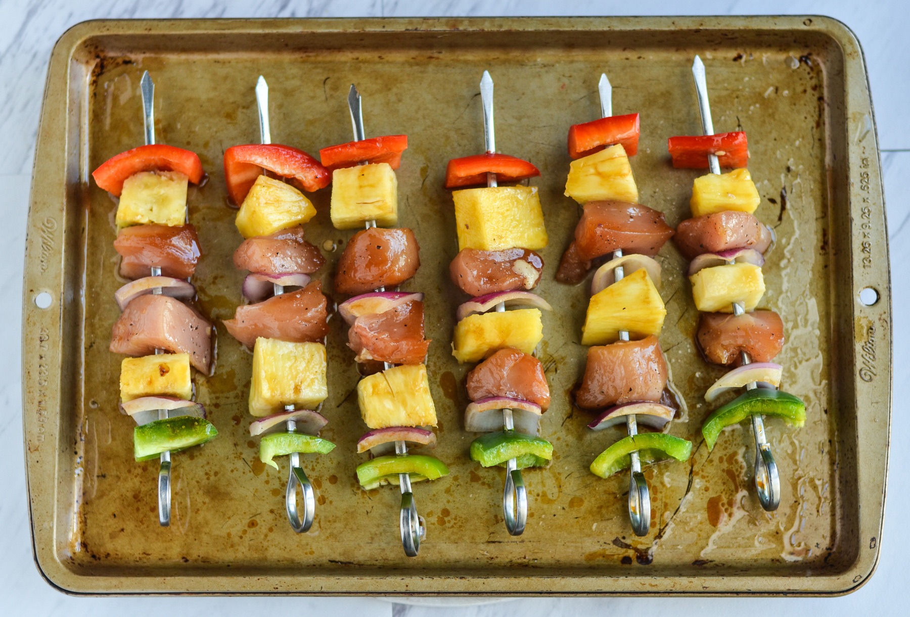 Pineapple chicken kebabs on skewers ready to grill