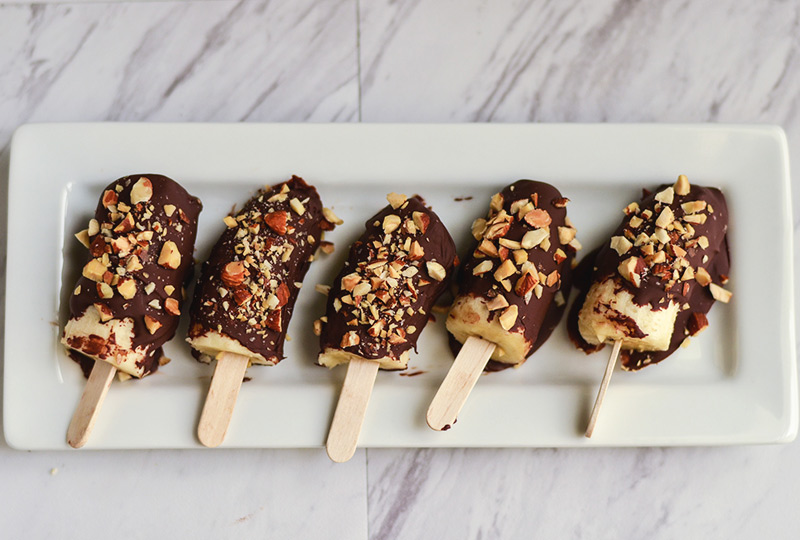 Frozen chocolate- and nut-dipped bananas on sticks