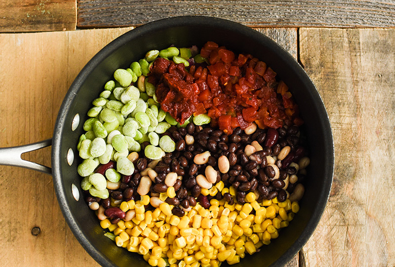 4 types of beans, corn and tomatoes in a pot