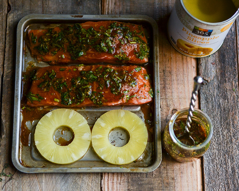 Salmon fillets and pineapple rings on a baking sheet