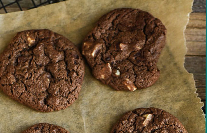 Triple chocolate cookies cooling on parchment paper