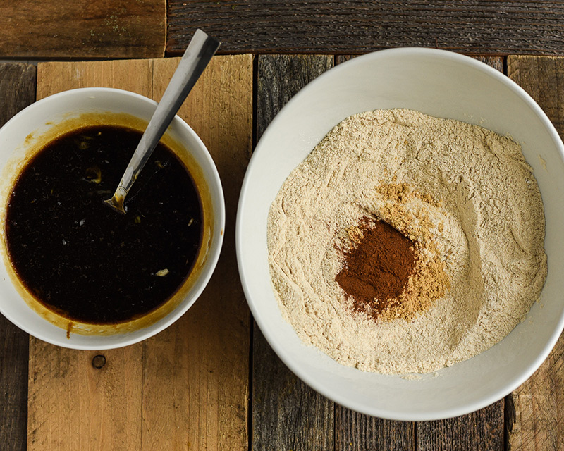 Bowl of molasses and bowl of flour mixed with cinnamon.