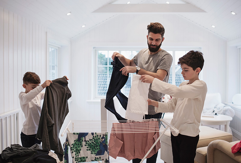 Father and two sons put away laundry