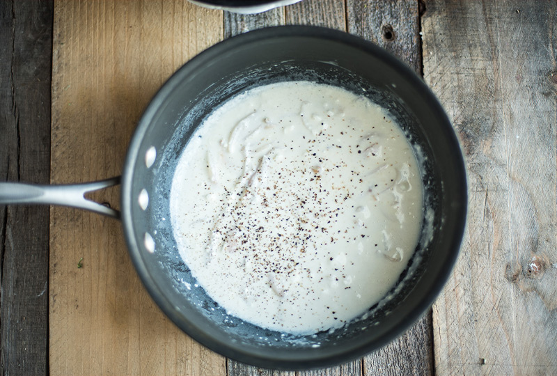 Milk, cream cheese, shallots and nutmeg cooked in a saucepan.