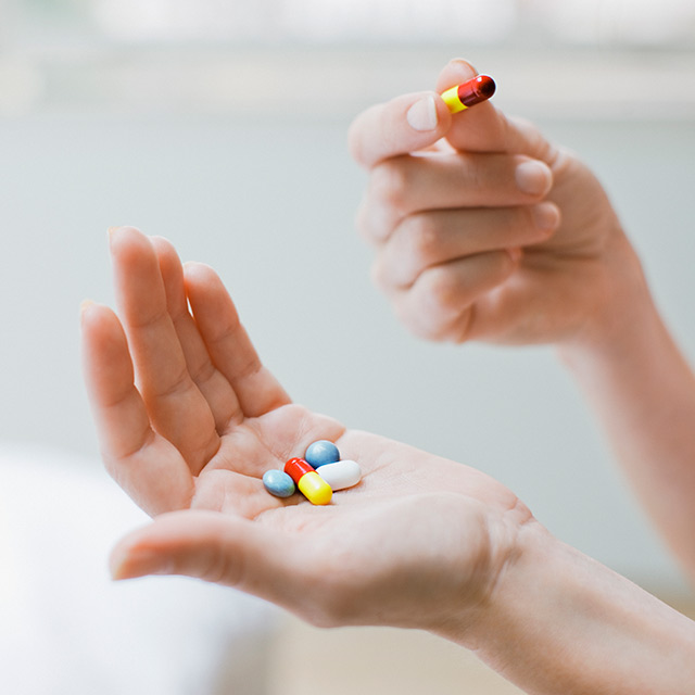 Woman holds several pills in her palm