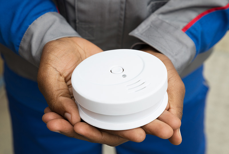 Closeup of a new smoke detector in a man's hands
