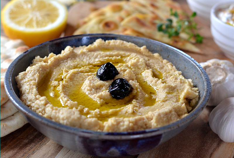 Bowl of hummus with olive garnish