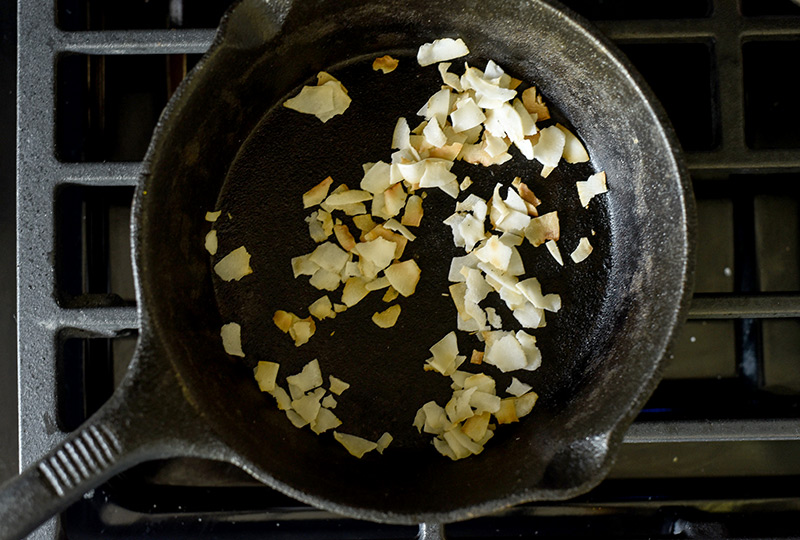 Coconut flakes toasting in a skillet