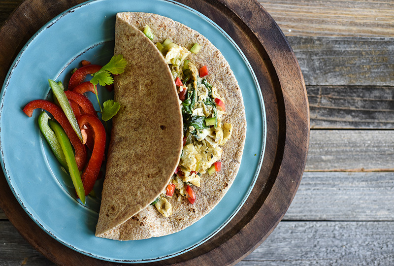 Eggs scrambled with vegetables, folded into a tortilla