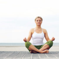 Woman sitting crosslegged in a yoga pose