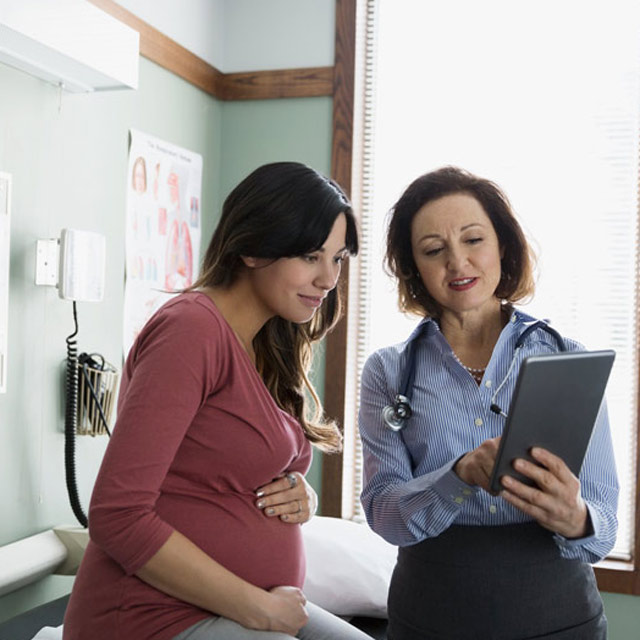 Pregnant woman talks with a healthcare provider.