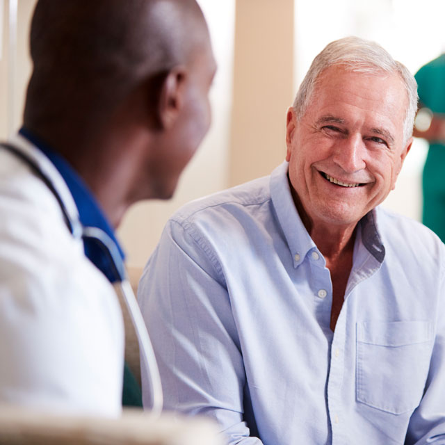 Older patient utilizing Medicare wellness exam to speak with doctor.