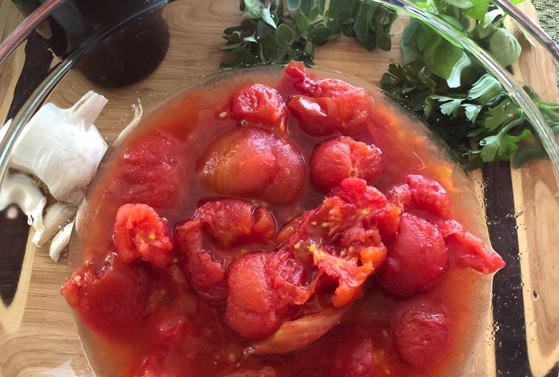 Bowl of hand-crushed cooked tomatoes and their juice