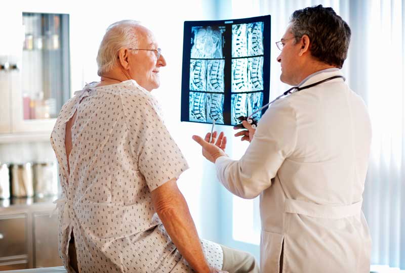 Doctor reviewing X-ray with spine surgery patient